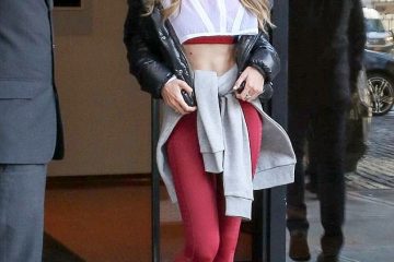 Gigi Hadid flaunts her sculpted midsection in burgundy leggings and a sports bra with a cropped jacket in NYC