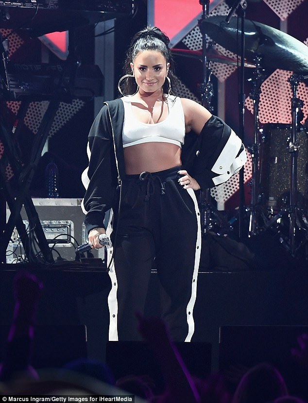 Demi Lovato bares her belly in bra-top and tracksuit for Atlanta’s Jingle Ball