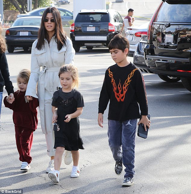 Kourtney Kardashian cuts a chic figure in all white for lunch outing with kids